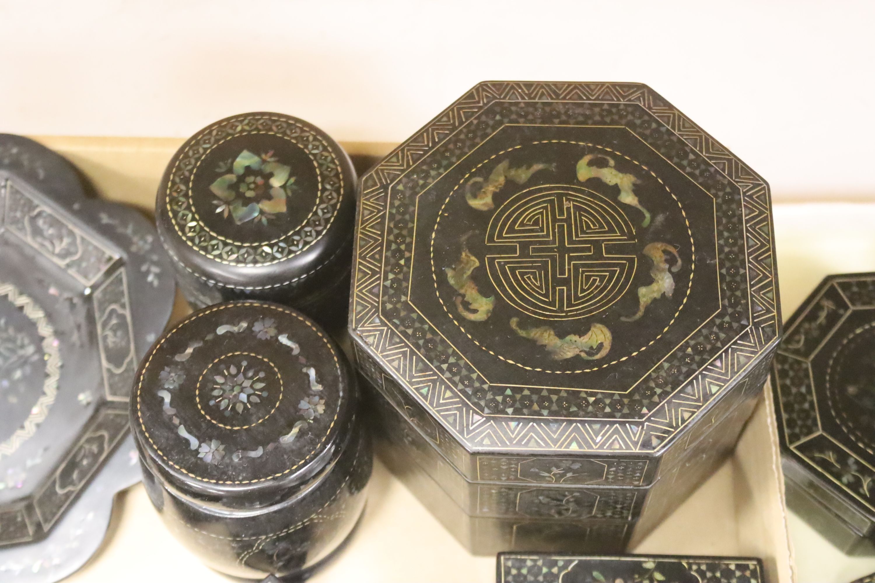 A quantity of Lac Burgaute boxes, inlaid with mother of pearl, largest 13cm diameter 10cm high (26)